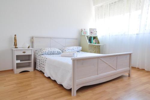 斯普利特内拉海滩公寓的卧室配有白色的床、梳妆台和窗户。