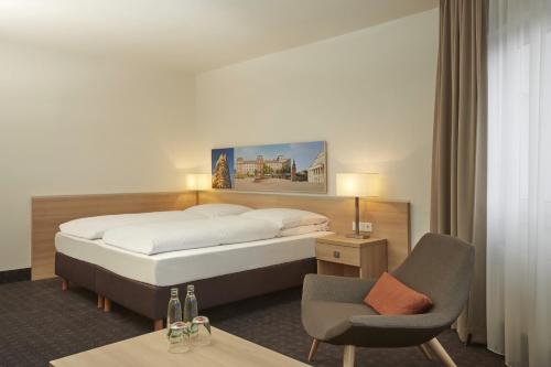 达姆施塔特达姆施塔特H +酒店的配有一张床和一把椅子的酒店客房
