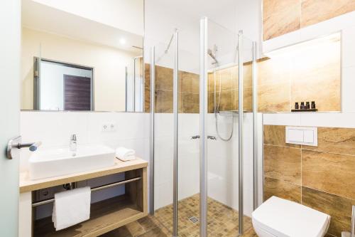 克洛彭堡SKY Hotel Cloppenburg的带淋浴、盥洗盆和卫生间的浴室
