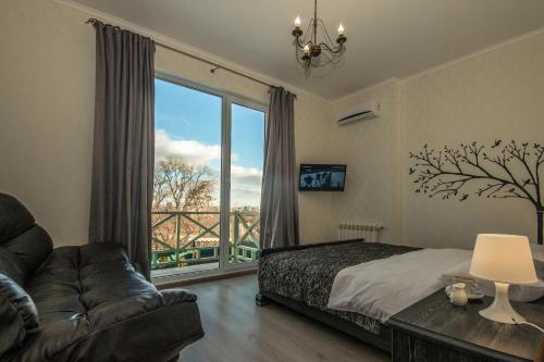 哈尔科夫利里维迷你酒店的一间卧室配有一张床、一张沙发和一个大窗户