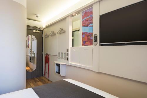 伦敦伦敦肖尔迪奇酒店的卧室配有壁挂式大屏幕平面电视。