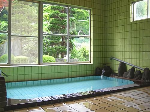 雫石町荣弥温泉民宿的绿色客房的游泳池,设有窗户