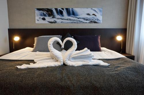 雷克雅未克雷克雅未克福斯酒店的床上用毛巾制成的两天鹅