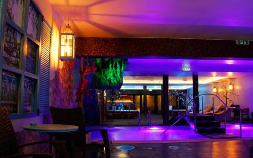 塔林Lavendel Spa Hotel的餐厅内紫色灯的房间