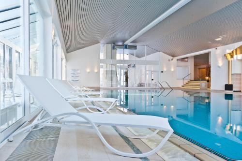 上施陶芬MONDI Resort und Chalet Oberstaufen的一座带白色椅子的游泳池