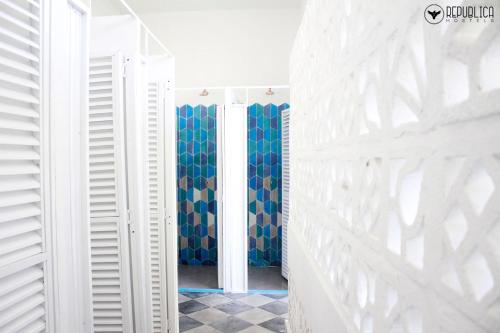 卡塔赫纳República Hostel Cartagena的走廊上设有白色的墙壁和蓝色的窗帘