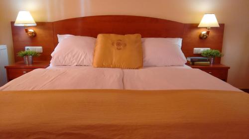 扎顿Aparthotel Lekavski的一间卧室配有一张大床和两个枕头