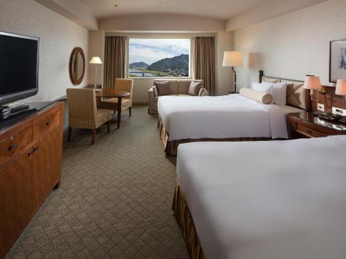 岐阜岐阜长良川都酒店的酒店客房设有两张床和一台平面电视。