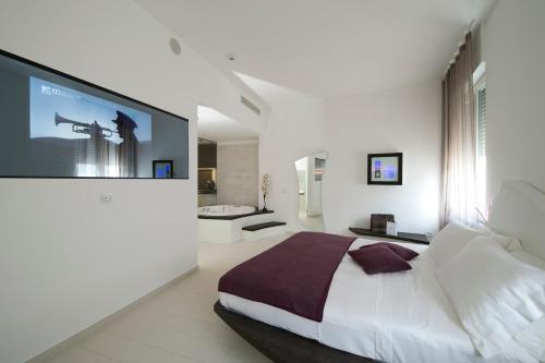 米兰多莫公寓酒店的一间带大床的卧室和一间浴室