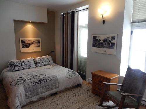 魁北克市Gite (B&B) du Vieux-Port的卧室配有床、椅子和窗户。