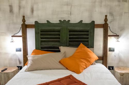 诺维利古雷ViaBasso11 Guest House的一张带绿色床头板和橙色枕头的床