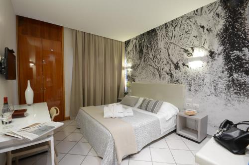 卢卡Hotel Napoleon的配有一张床和一张书桌的酒店客房