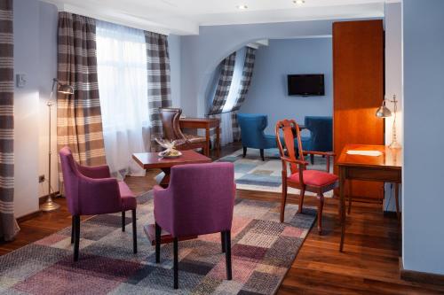 乌斯特卡Hotel Rejs的客厅配有紫色椅子和桌子