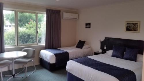 亚拉腊亚拉特南十字汽车旅馆 的酒店客房设有两张床、一张桌子和一个窗户。