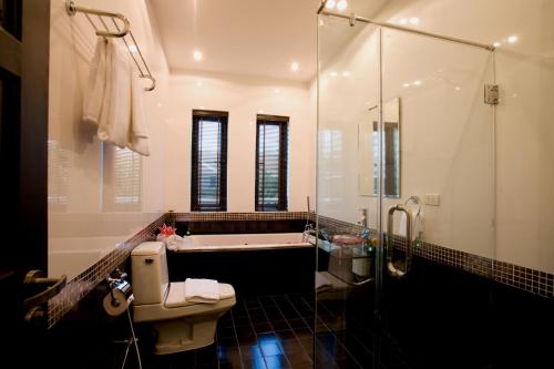 纳仲天芭堤雅棕榈林度假酒店的带浴缸、卫生间和淋浴的浴室。