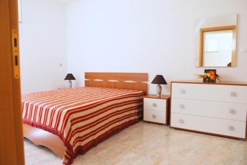 科尔萨诺Appartamento Roberti的一间卧室配有一张床、梳妆台和镜子