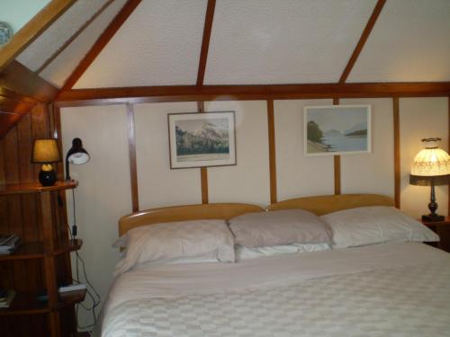 奥玛鲁联邦住宿加早餐旅馆的墙上有两张照片的房间的一张床位