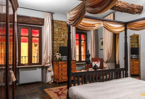 蒙福特达尔巴迪莫拉马尼切一号公寓的一间卧室配有一张天蓬床、一张书桌和窗户。