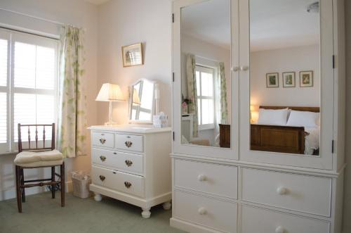 阿宾汉姆霍丽斯住宿加早餐旅馆的卧室配有大型白色梳妆台和镜子