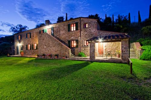 科尔托纳Mulino a Vento的一座大型石头房子,晚上有院子