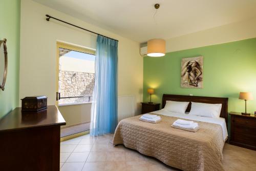 斯法卡基Malena Villa, beach retreat, By ThinkVilla的一间卧室配有一张带蓝色窗帘的床和一扇窗户