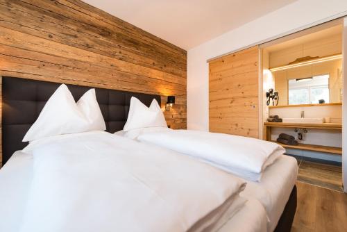 弗拉绍APART Forellenhof的卧室配有一张白色大床和木墙