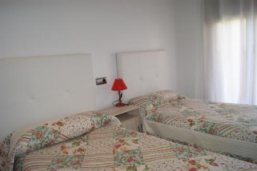 阿尔考斯布里Alcocebre Beach Resort的一间卧室配有两张床和一张带台灯的桌子