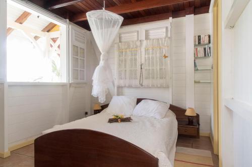 圣安娜L'escapade的一间白色墙壁的房间,卧室配有床铺