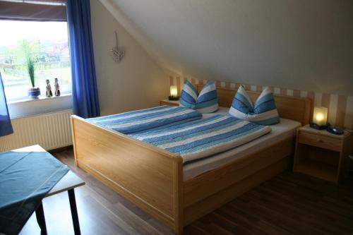 奥利希斐科特宾馆的一间卧室配有一张带蓝色枕头的床和一扇窗户。