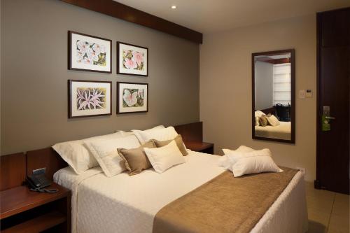 圣克鲁斯科尔特斯酒店的卧室配有一张带镜子的白色大床