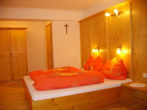 埃布斯维达阿舒适旅馆的一间卧室配有带橙色枕头和十字架的床
