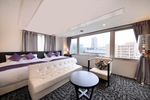 福井百夫长酒店别墅套房福井站前的一间酒店客房,设有一张大床和一个大窗户