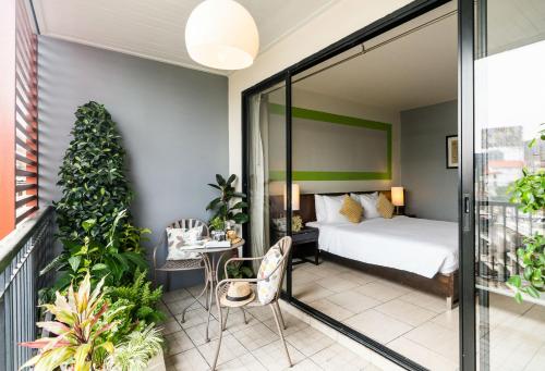 曼谷乐曼谷酒店的卧室配有一张床和一张桌子及椅子
