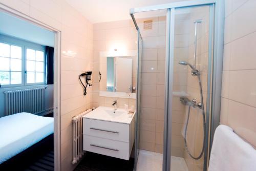 瑟松塞维涅乐生发酒店的带淋浴、盥洗盆和卫生间的浴室