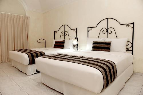 圣克鲁斯Buganvillas Hotel Suites的白色的酒店客房内的两张床