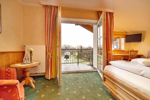 Westendorf格鲁堡酒店的酒店客房设有一张床和一个阳台。