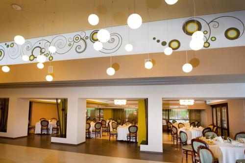 布泽乌皮特瑞萨酒店的一间设有白色桌椅的用餐室