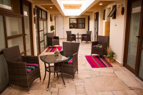 圣佩德罗·德·阿塔卡马Hostal Anpaymi Atacama的庭院设有藤椅和桌子。