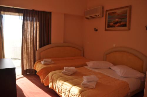 美西尼德鲁西亚酒店的两张位于酒店客房的床,配有毛巾
