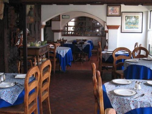 Apizaco拉波萨达酒店的一间配备有桌椅及蓝桌布的用餐室