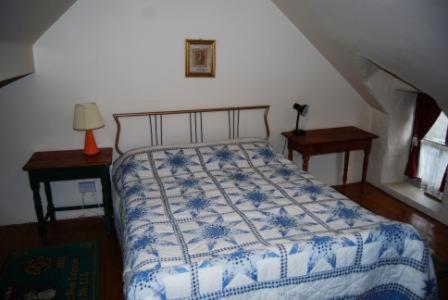 瓦伦西亚岛Cul Cottage的一间卧室配有一张带蓝白色毯子的床