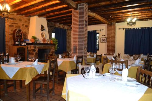 Encinasola林孔阿贝德酒店的餐厅配有桌椅和白色桌布