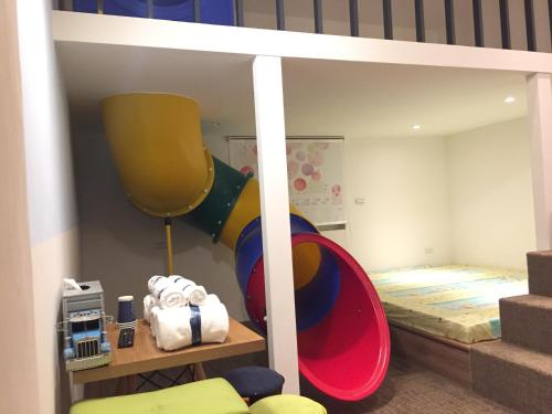 高雄聚所的儿童卧室配有双层床和滑梯