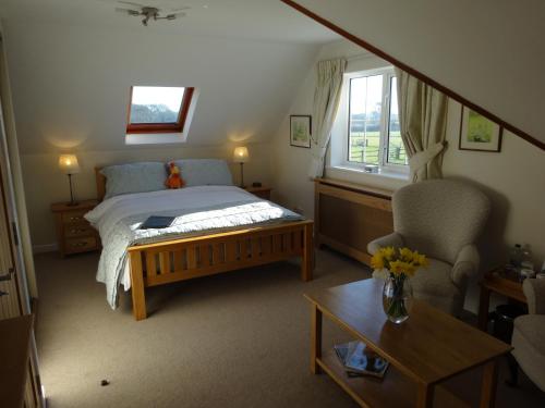 Sway克罗夫特猎人住宿加早餐旅馆的卧室配有床、椅子和窗户。
