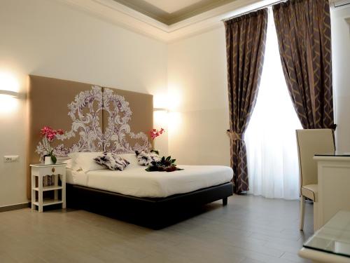罗马简单客房旅馆的卧室配有1张特大号床,位于窗户前