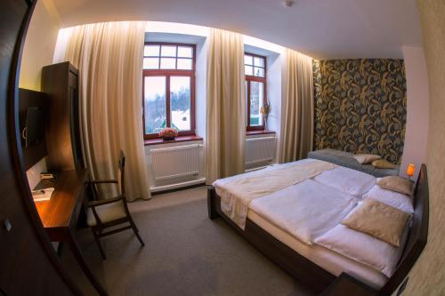 耶塞尼克斯拉尼德芙酒店的卧室配有一张床、一张书桌和窗户。