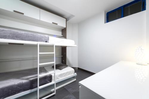 大加那利岛拉斯帕尔马斯Suites Apartamento 17的一间卧室配有双层床和书桌