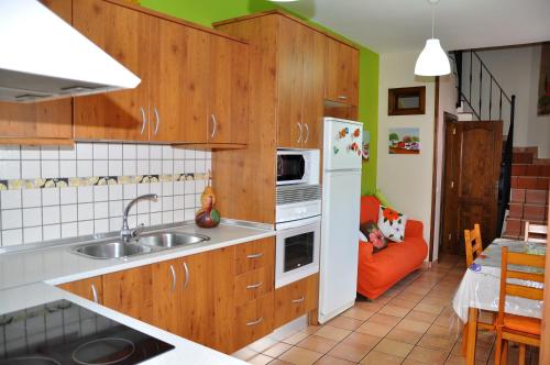 巴尔塞基略Casa Paco Las Vegas的厨房配有木制橱柜和橙色沙发。