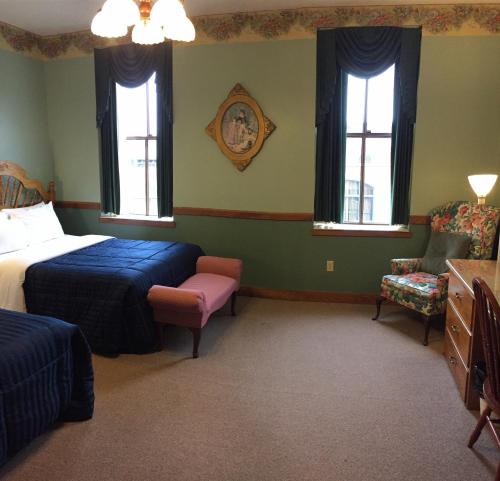 米勒斯堡米勒斯堡酒店的一间卧室设有两张床、一把椅子和窗户。