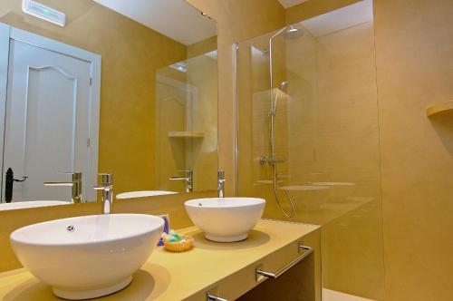 阿瓜阿马加阿瓜阿马加家庭酒店的一间带两个水槽和玻璃淋浴间的浴室